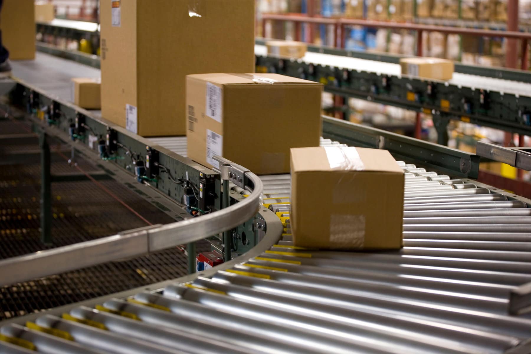 Various size boxes move down the conveyor in a distribution facility