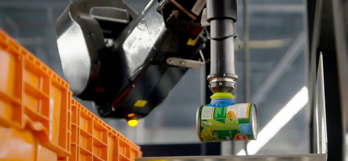 A Berkshire Grey Robotic Pick Station (BG RPS) solution picks a can of peas for sorting into a grocery order.