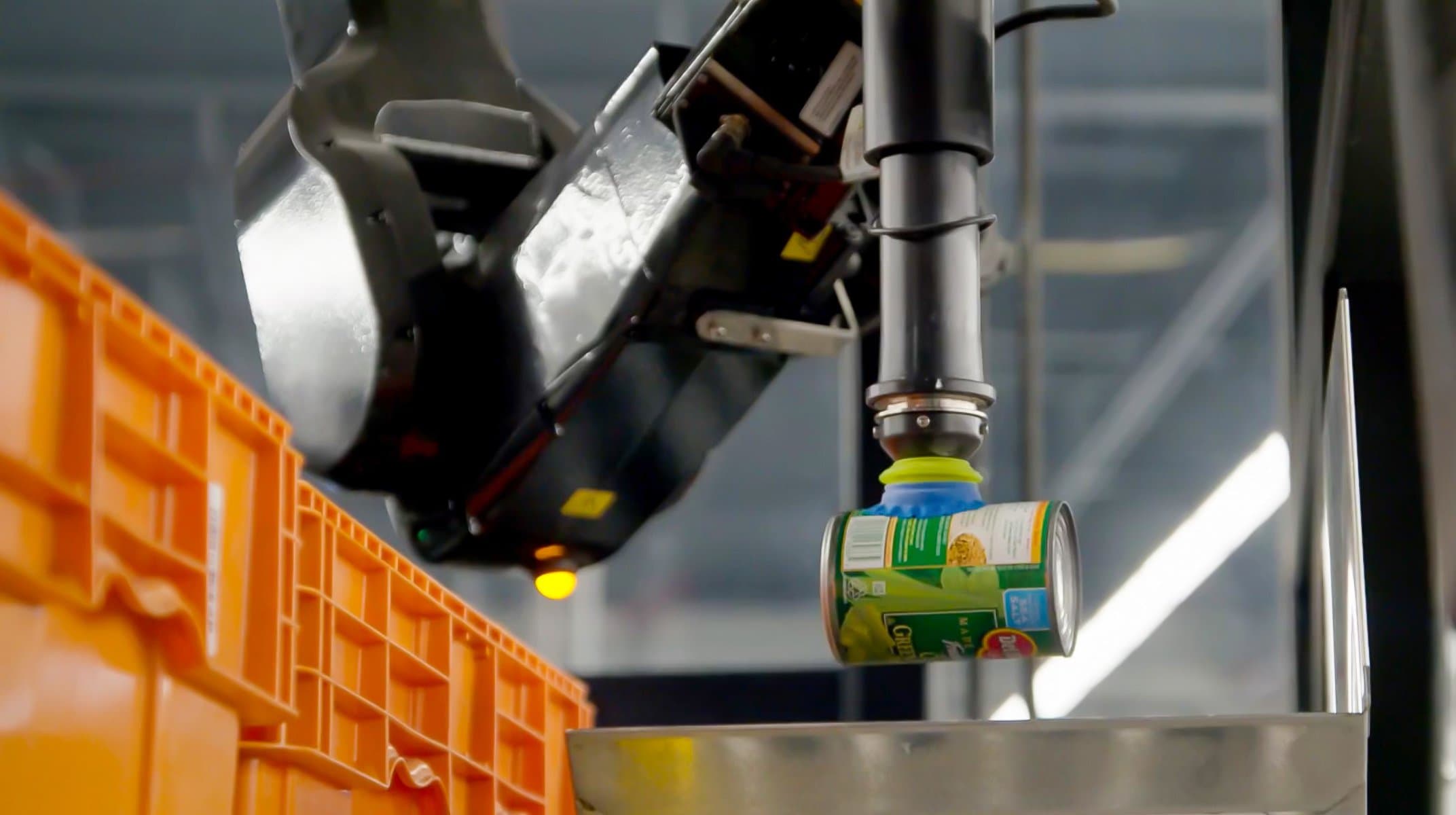 A Berkshire Grey Robotic Pick Station (BG RPS) solution picks a can of peas for sorting into a grocery order.