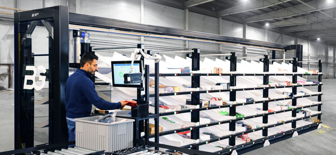 Berkshire Grey Robotic Shuttle Put Wall operator is barcoding a SKU to be sorted for an eCommerce order