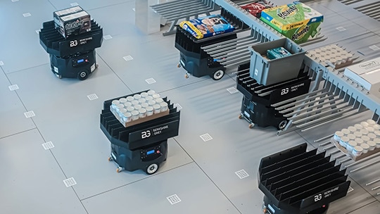 A swarm of BG FLEXbots transfer goods to low-density storage for sequencing and eCommerce order fulfillment
