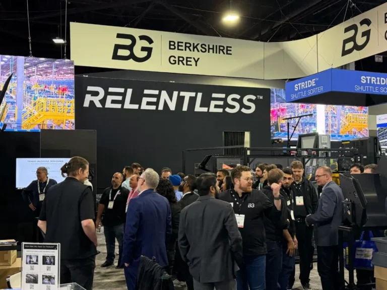 Crowd of attendees gathered at the Berkshire Grey booth during a trade show.